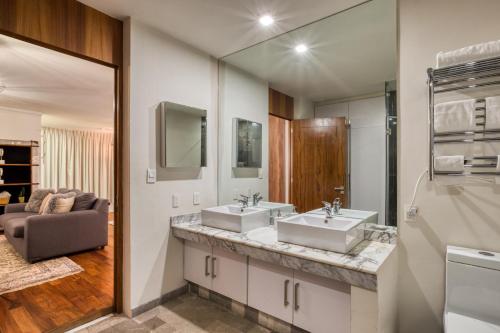 Un baño con dos lavabos y un espejo grande. en Hotel Livin Condesa, en Ciudad de México