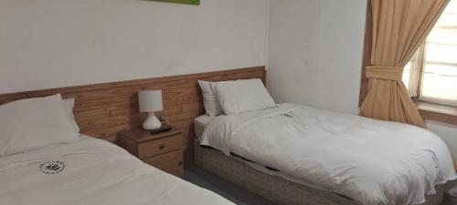 a bedroom with two beds next to a window at Santuario del Río in San José de Maipo