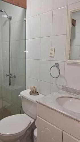 a white bathroom with a toilet and a sink at Santuario del Río in San José de Maipo
