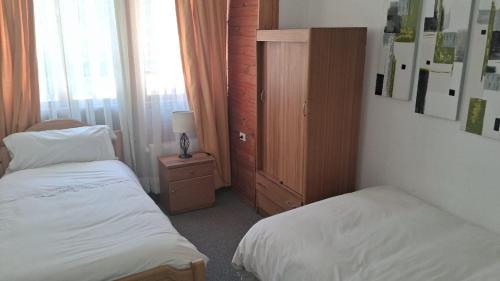 a small bedroom with two beds and a cabinet at Santuario del Río in San José de Maipo
