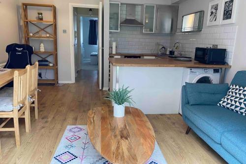 a living room with a table and a blue couch at Beautiful 1 Bedroom Flat Close to the City Centre in London