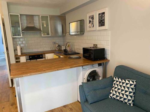 a kitchen with a counter with a microwave and a washing machine at Beautiful 1 Bedroom Flat Close to the City Centre in London