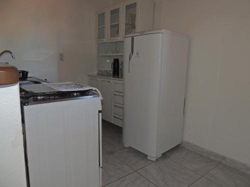a kitchen with a white refrigerator and a stove at Nossa Casa em Jeri in Jericoacoara