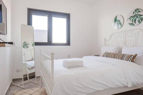 Un dormitorio blanco con una cama blanca y una ventana. en O&O Group- Magical 4BR APT With Panoramic Sea View, en Bat Yam