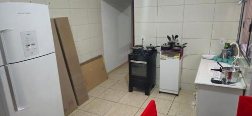 a small kitchen with a stove and a refrigerator at Casa 2 Quartos parte superior espaço inteiro in Indaiatuba
