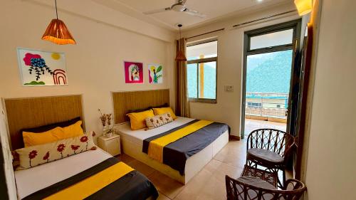 a bedroom with two beds and a window at Bunk Hostel Rishikesh in Rishīkesh
