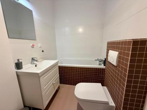 Un baño con inodoro, lavabo y bañera. en Aluzyjna Residence by JumpInHere, en Varsovia