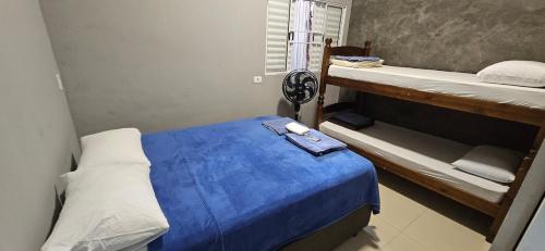 Un dormitorio con dos literas y una cama azul. en Loft A Hospede-se em Frente ao Parque ecológico, en Indaiatuba
