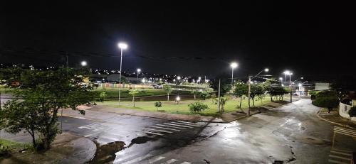 un estacionamiento vacío con luces de la calle por la noche en Loft A Hospede-se em Frente ao Parque ecológico, en Indaiatuba