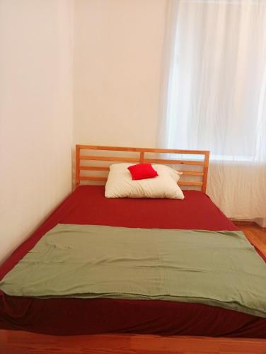 a bedroom with a bed with a red and white pillow at StaySpace in Graz