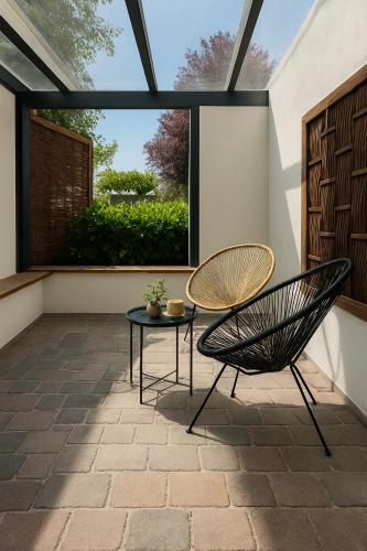 a patio with two chairs and a table at Moderne Ferienwohnung Klosterblick in Guxhagen