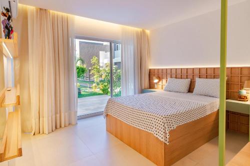 ein Schlafzimmer mit einem Bett und einem großen Fenster in der Unterkunft Condomínio Mantra em São Miguel do Gostoso in Reduto