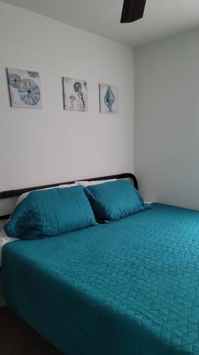 a bed with a green comforter in a room at Nassau Homestay in Opa-locka