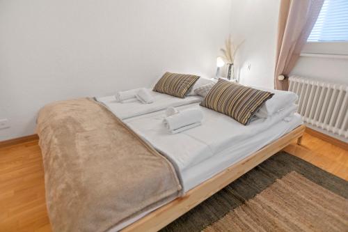 Crans-Montana - Studio centre 2 pers - Rue du Prado في Lens: سرير بشرشف ووسائد بيضاء في الغرفة