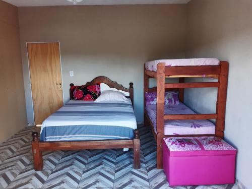 a bedroom with two bunk beds and a suitcase at La Orlinda in Potrero de Garay