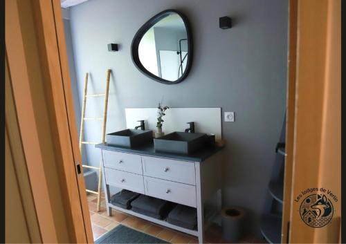 a bathroom with a mirror and a white dresser at Les lodges de Verlin in Verlin