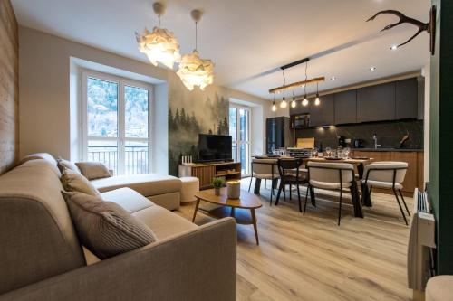 a living room and kitchen with a couch and a table at 3 Vallées & cycling Cosy 6 to 8 in the Alps in Orelle
