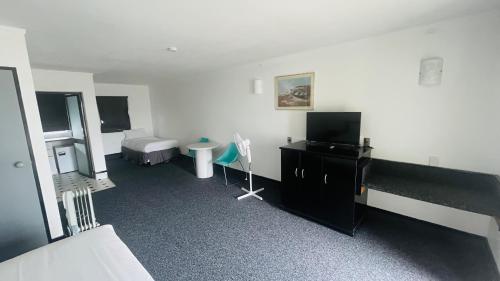 a room with a bedroom with a bed and a television at Alcamo Motel in Hamilton