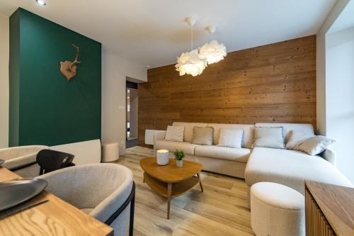 a living room with a couch and a table at 3 Vallées & cycling Cosy 6 to 8 in the Alps in Orelle