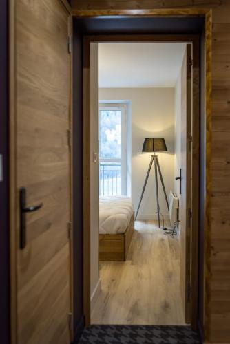 a door leading into a bedroom with a bed at 3 Vallées & cycling Cosy 6 to 8 in the Alps in Orelle