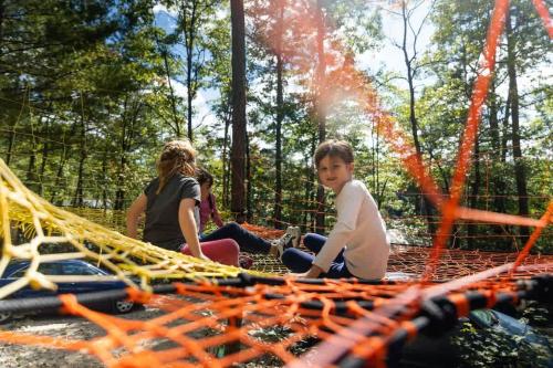 a group of people sitting on a net at Tent #1 - The Whippoorwill's Nest in Rogers