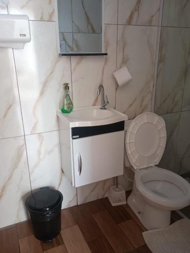 Un baño con un lavabo blanco y un inodoro. en Pousada Nossa Senhora Da Polônia, en Cachoeira Paulista