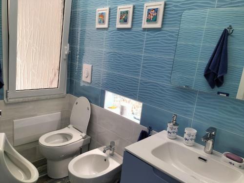 a blue bathroom with a toilet and a sink at Casa vacanze Villa Yoelis in Sellia Marina