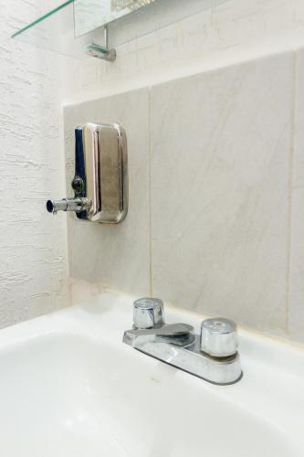 a bathroom sink with a soap dispenser on the wall at Departamento-Rinconcito Uxmal in Playa del Carmen