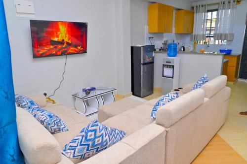 a living room with a couch and a fire in the wall at GILGAL Homes in Kisii