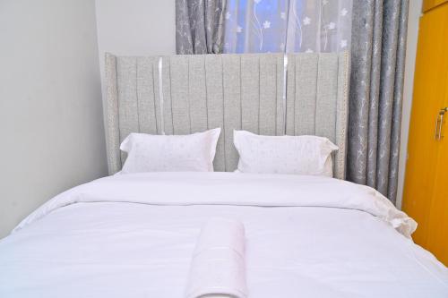 a bed with white sheets and pillows in a room at GILGAL Homes in Kisii