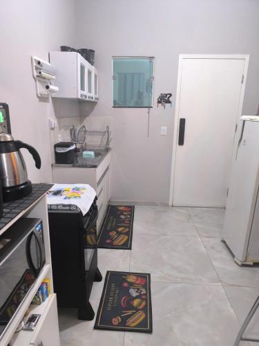a small kitchen with a stove and a refrigerator at Refúgio Black in Sabará