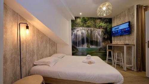 una camera da letto con un murale a cascata sul muro di Studio pratique et cosy Rouen centre a Rouen