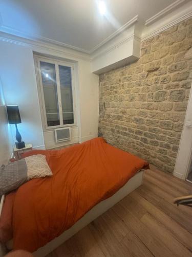 a bedroom with a bed and a brick wall at New apartment rue de Fontenay in Vincennes