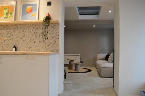 a kitchen and a living room with a couch at Maison au coeur du village in Aubel