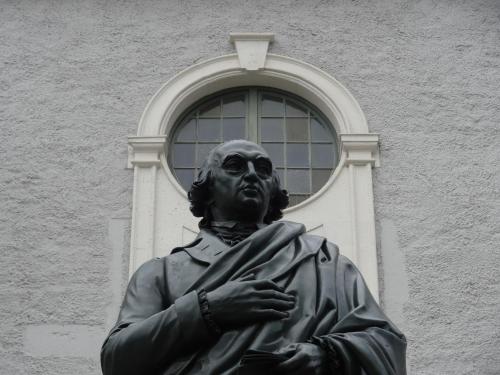 a statue of a man in front of a window at "goethezimmer" an der Herderkirche in Weimar