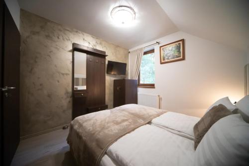 a bedroom with a bed and a window at Pensiunea Rezkakas in Balvanyos