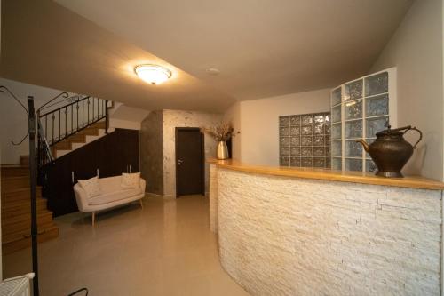 a room with a bar with a staircase and a couch at Pensiunea Rezkakas in Balvanyos