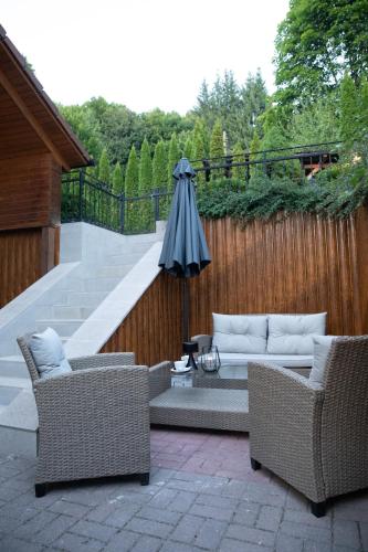 a patio with two chairs and an umbrella at Pensiunea Rezkakas in Balvanyos