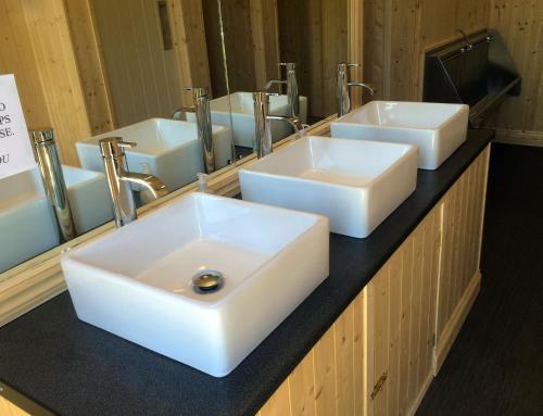 a bathroom with three white sinks and a mirror at Oxford Riverside Glamping in Oxford