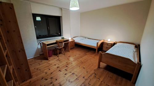 a room with two beds and a desk and a window at Wohnung Brand in Neumarkt in der Oberpfalz