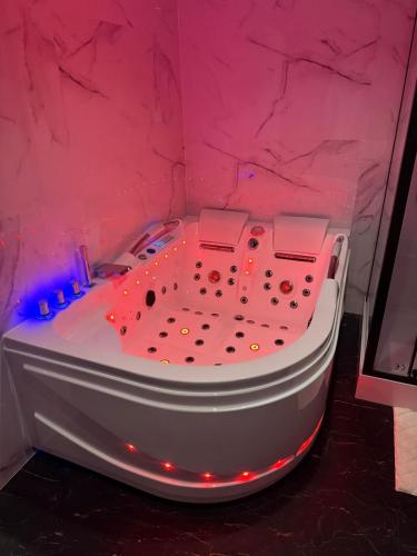 a hot tub in a pink room with lights at Ombre et Douceur in Josselin