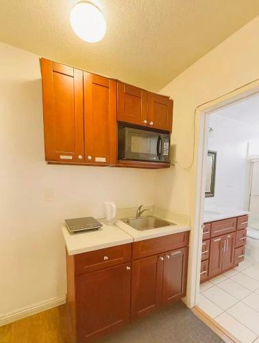 a kitchen with a sink and a microwave at Coastal Comfort Homestay in Santa Monica in Los Angeles