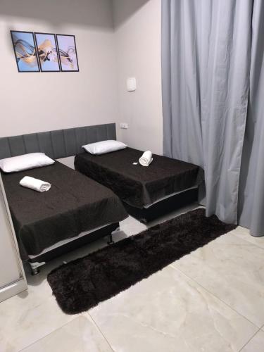 two twin beds in a room withskirts at Refúgio Black in Sabará
