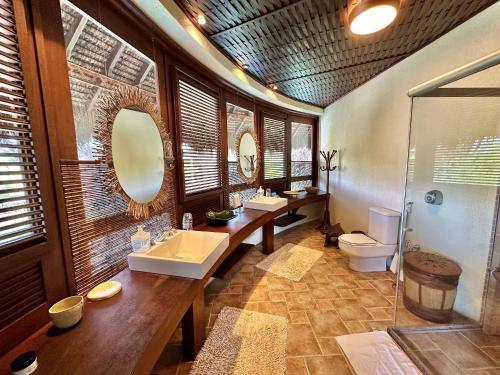 a bathroom with two sinks a toilet and a shower at Condomínio Marina Jaguari in Benfica