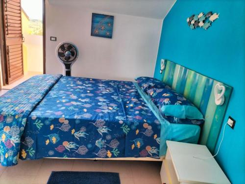 a bedroom with a bed with a blue bedspread at Casa vacanze Villa Yoelis in Sellia Marina