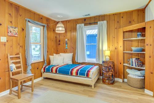 a bedroom with wooden walls and a bed and a window at Cozy Cottage Just 2 Blocks From the River! in Colonial Beach
