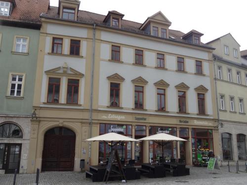 a large building with two umbrellas in front of it at "goethezimmer" an der Herderkirche in Weimar