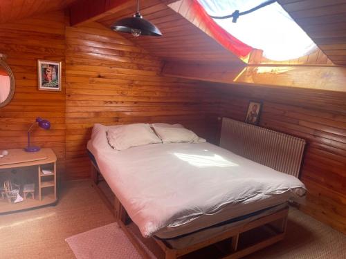 una camera da letto con un letto in una cabina di legno di Maison de campagne a Barbaste