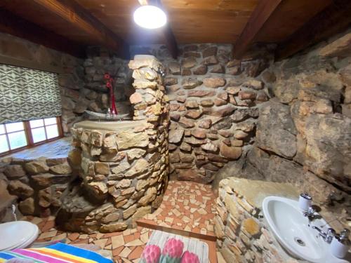 a stone bathroom with a sink and a stone wall at Rondeberg Holiday Resort in Clanwilliam