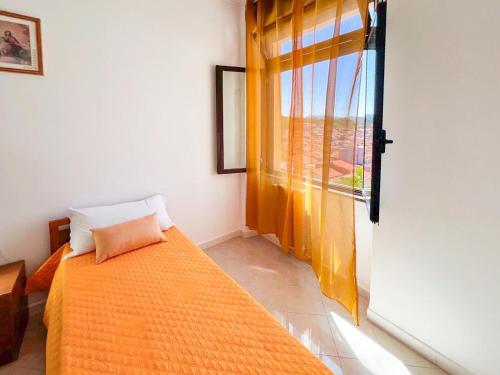 a bedroom with a bed and a large window at Brebei Niedda Hostel in Gonnesa